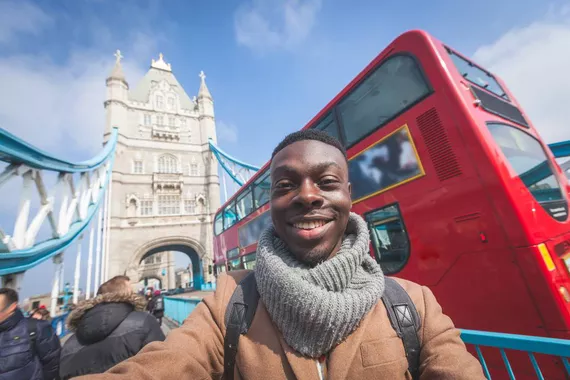 Homem tirando selfie em Londres, com Tower Bridge no fundo